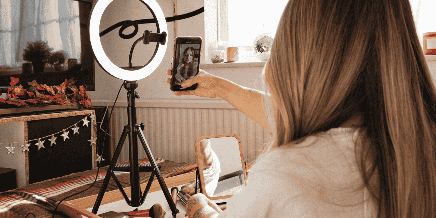 Content creator hosting a TikTok Live session with a smartphone and ring light, demonstrating how live giveaways are run on the platform to engage viewers.