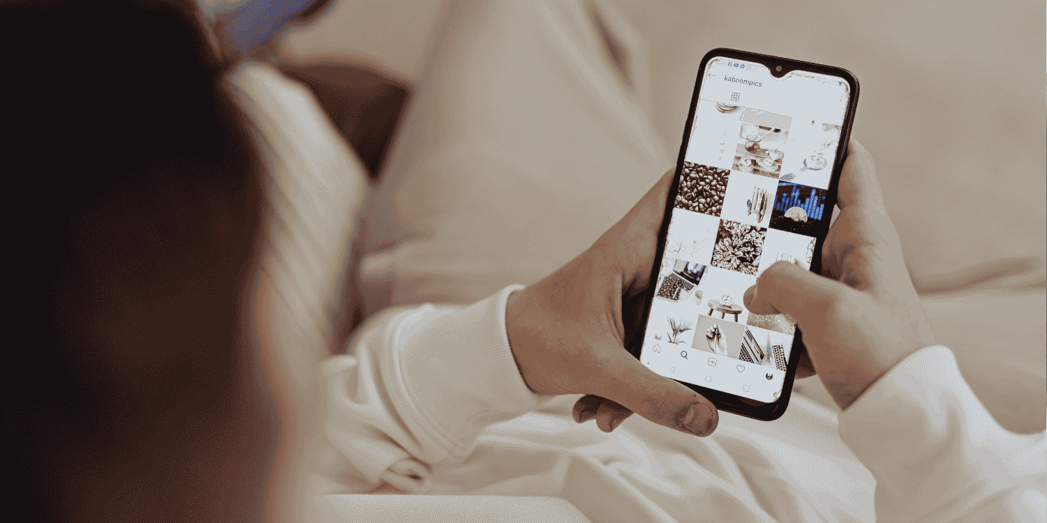 Person browsing an Instagram profile grid on a smartphone while relaxing—illustrating the concept of "How to Do Giveaways on Instagram"
