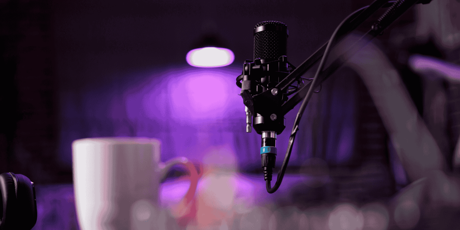 Professional microphone setup with headphones and a coffee mug on a desk under purple lighting—representing a streaming or Discord environment related to "How to Enter Discord Giveaways".