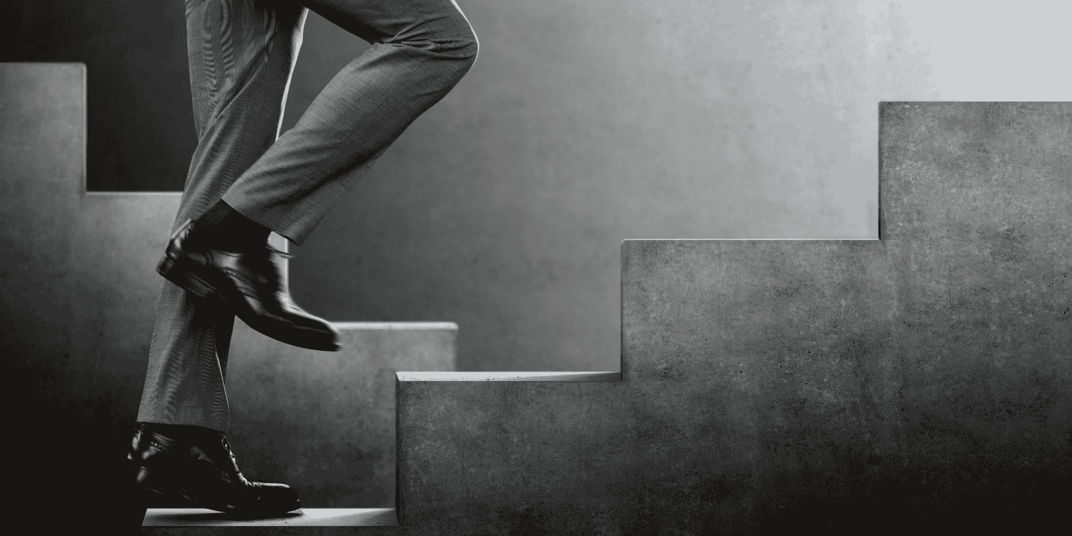 Businessperson stepping upward on concrete stairs, symbolizing the step-by-step process of launching successful Instagram giveaways