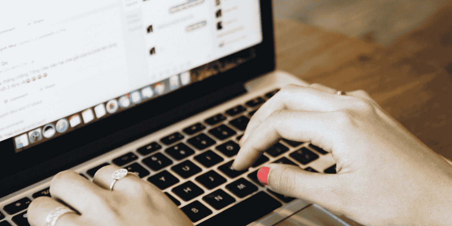Person typing on a laptop, actively engaging in Facebook posts and messages to promote an ongoing giveaway campaign.