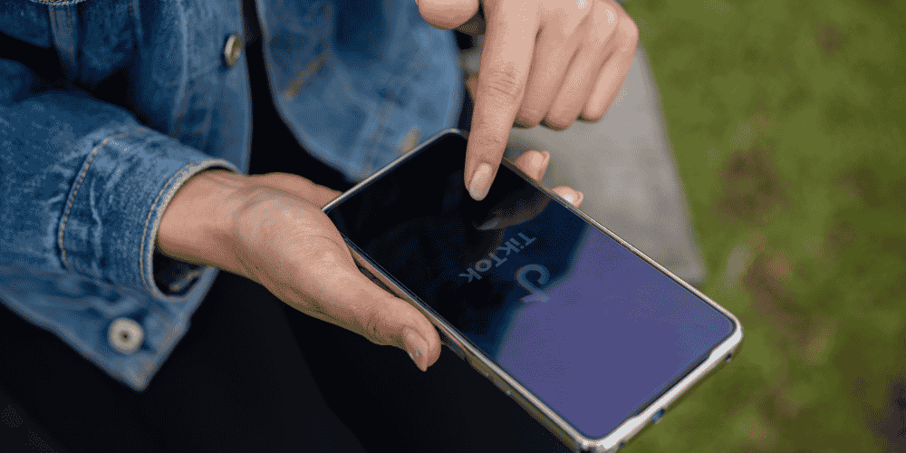 Person using a smartphone with the TikTok app loading on screen—representing participation and strategy related to "How to Win TikTok Giveaways".